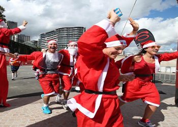 Some of the 4000 Santa's that took part in the Variety Santa Run cross the finish line at The Sydney Opera House, today.