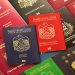 Blue and red biometric passports of United Arab Emirates on background of various documents of many countries of the world