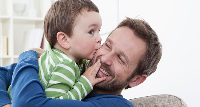 Germany, Bavaria, Munich, Son (2-3 Years) kissing his father, smiling