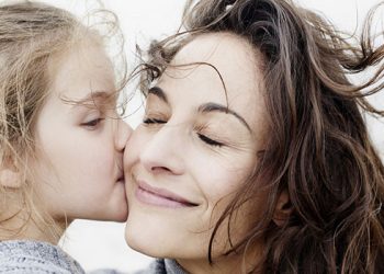 Daughter kissing mother outdoors