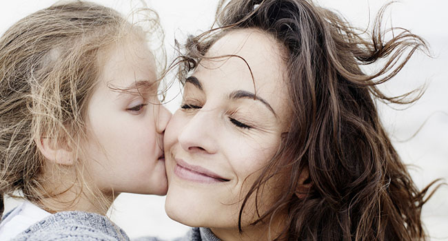 Daughter kissing mother outdoors