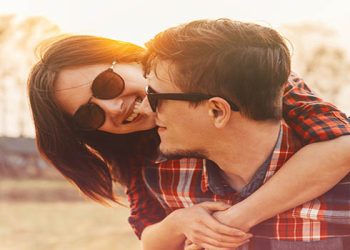 Smiling hipster couple in love woman embraces a man in sunny day