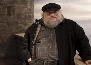 In this publicity image released by HBO, author George R.R. Martin whose novel series have been adapted into the HBO series "Game of Thrones," is shown on the set. (AP Photo/HBO, Nick Briggs )