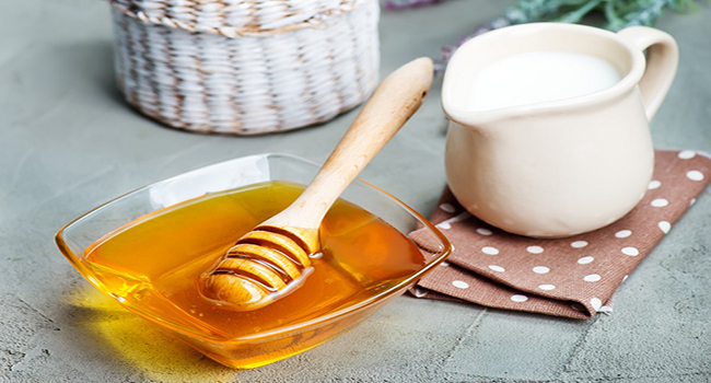honey in glass bank and on a table