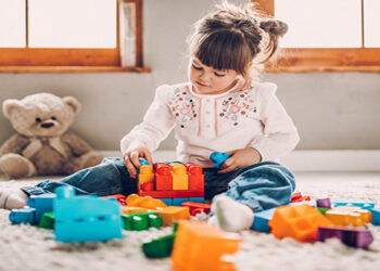 Sweet child playing with plastic blocks