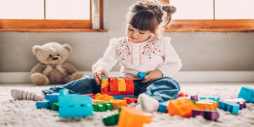 Sweet child playing with plastic blocks