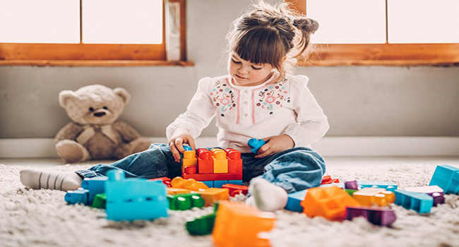 Sweet child playing with plastic blocks