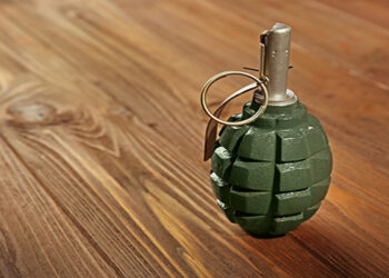 Close up view of hand grenade on wooden background
