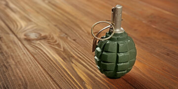 Close up view of hand grenade on wooden background