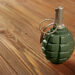 Close up view of hand grenade on wooden background
