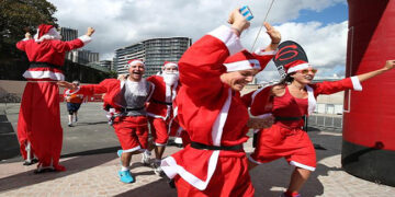 Some of the 4000 Santa's that took part in the Variety Santa Run cross the finish line at The Sydney Opera House, today.