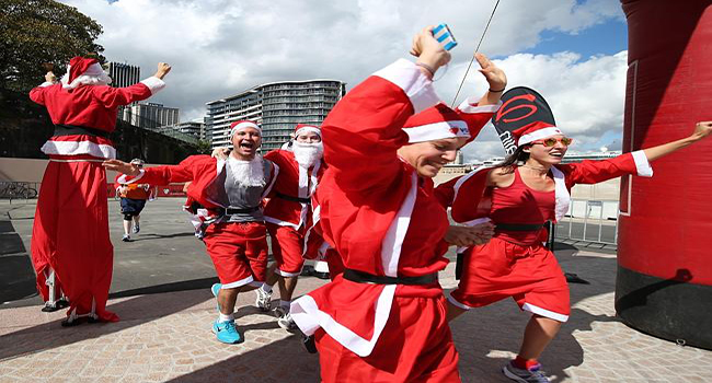 Some of the 4000 Santa's that took part in the Variety Santa Run cross the finish line at The Sydney Opera House, today.